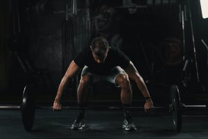 man in black tank top and black shorts doing push up